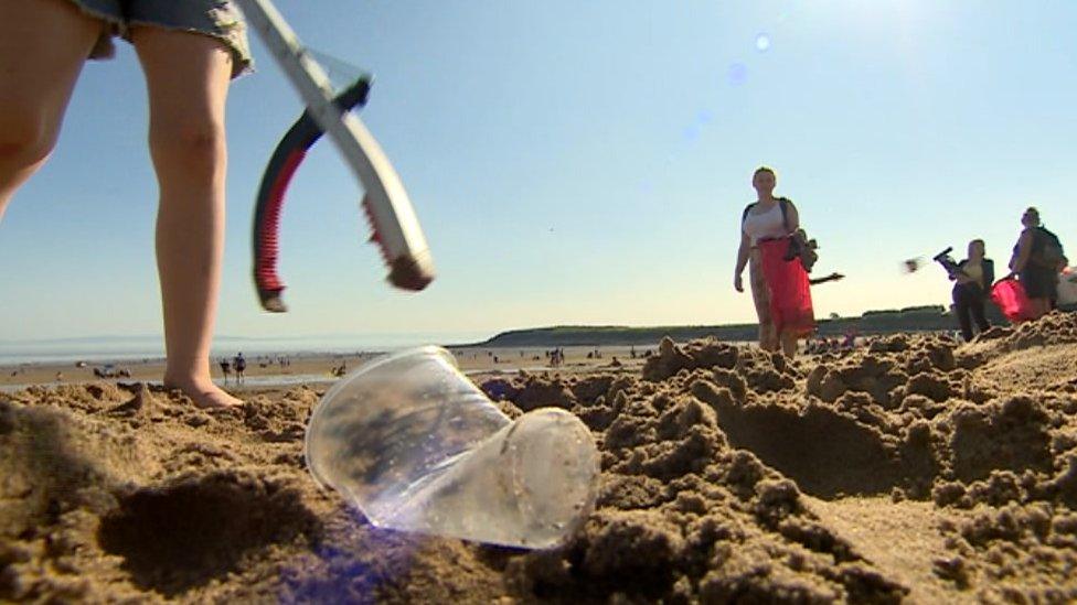 Plastic being picked up off the beach