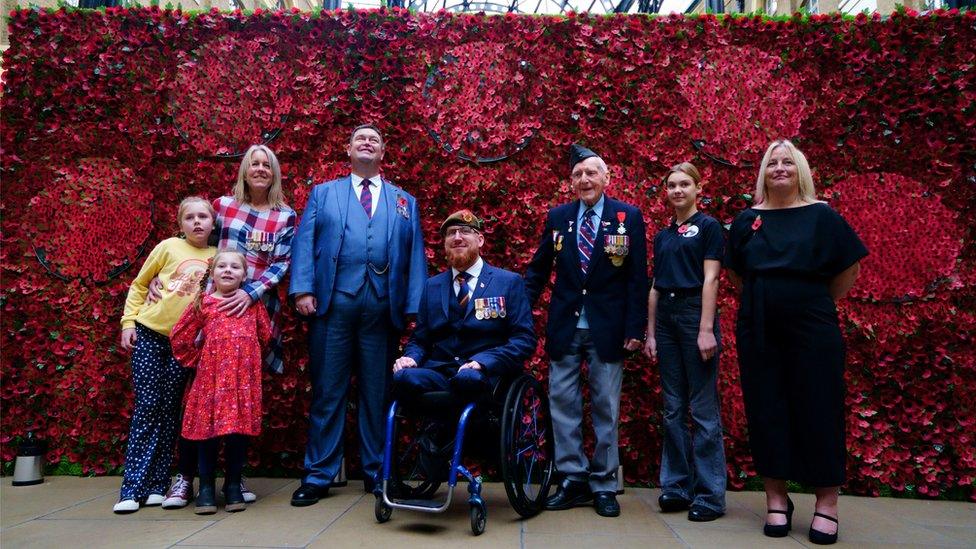 (L-R) Afghanistan Veteran Sally Renard with her daughters Daisy and Maya, Army Veteran Clive Jones, Afghanistan Veteran Anthony Cooper, 98-year-old D-Day Veteran Bernard Morgan, military child Imogen Nicol, and military widow Chantelle Wynn