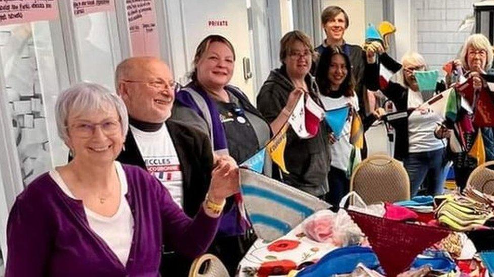 People from Beccles and Petit-Couronne holding up bunting