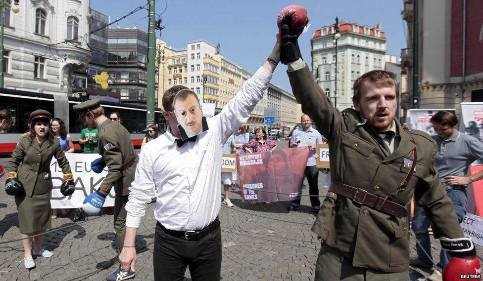 Activists, symbolically dressed as police officers and a referee depicting Azerbaijan President Ilham Aliyev (C), stage a protest to draw attention to what they say is the violation of human rights in Azerbaijan, ahead of the European Games in Baku, in central Prague, 12 June 2015.