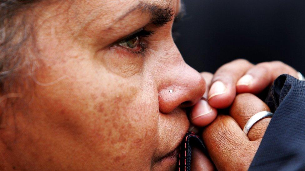 A woman watches the Australian government's apology to indigenous people