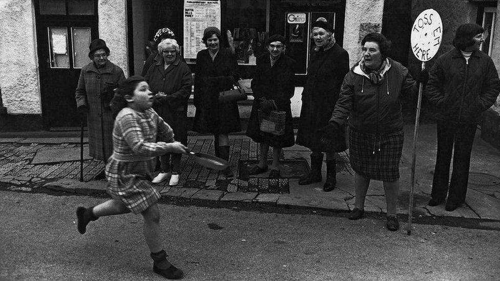 Diane Hiscock competing in the pancake race, Fore Street, Dolton, 1974