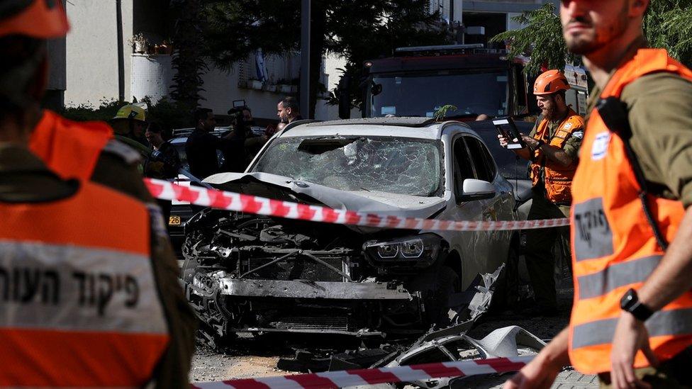 A wrecked car is pictured in a cordoned off area in Holon, Israel on 11 December