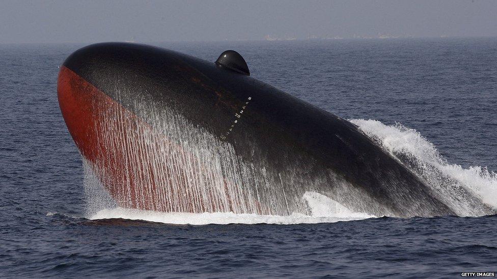 A Japanese Maritime Self-Defense Force submarine surfaces during a naval fleet review