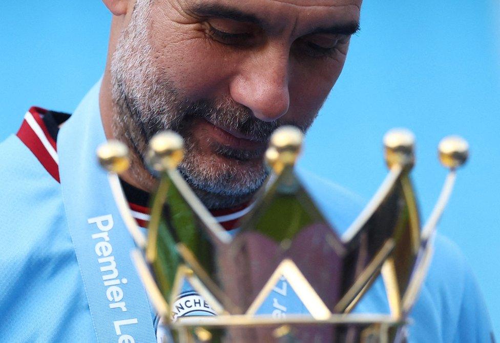 Manchester City manager Pep Guardiola celebrates with the trophy after winning the Premier League