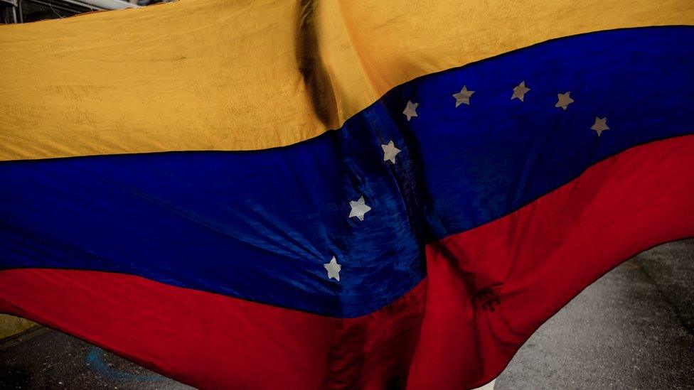 A shadow of a person seen through a Venezuela flag