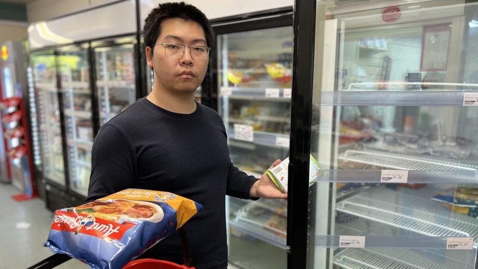 Cheng Gong standing next to freezer