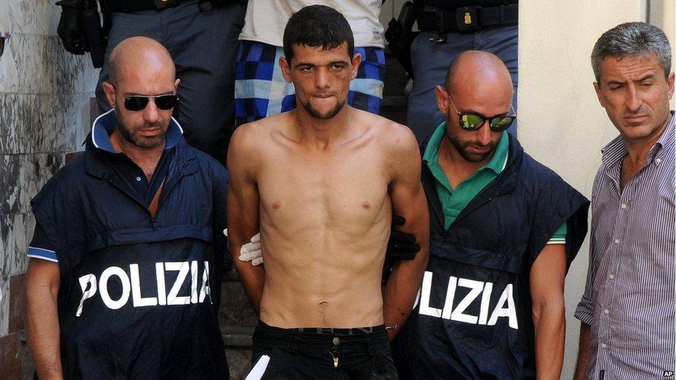 Italian police officers take in custody Ali Rouibah, centre, one of the five alleged smugglers who were detained (7 August 2015)