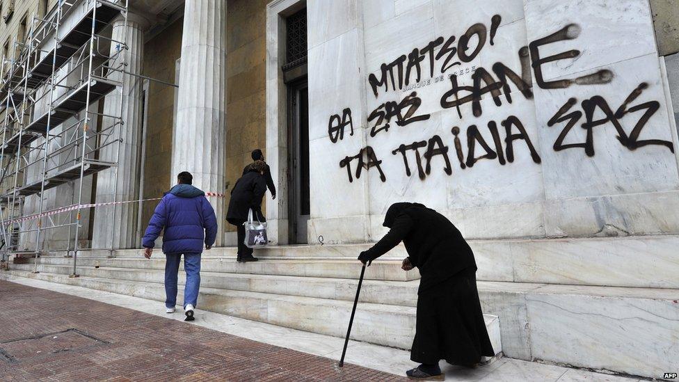 Woman begging outside bank of Greece, May 2015