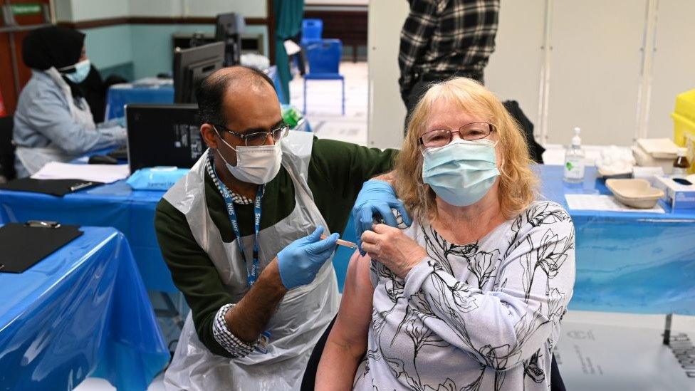 Pharmacist, Murtaza Abdulkarim administers a dose of the AstraZeneca/Oxford Covid-19 vaccine to a patient at a temporary vaccination centre, staffed by pharmacists and pharmacist assistants, at the Al-Abbas Islamic Centre in Birmingham, West Midlands on February 4, 2021.