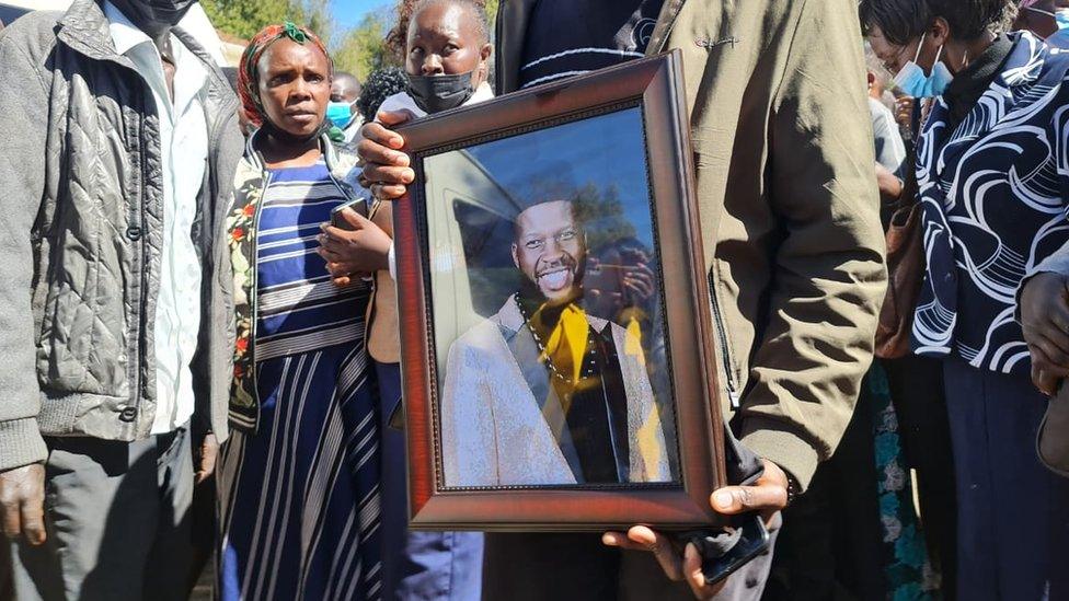 Person holding a picture of Edwin Chiloba