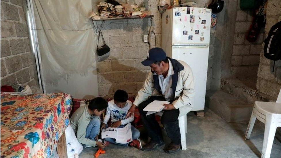 Facundo Martinez reviews school work with his children after a televised class as millions of students returned to classes virtually after schools were ordered into lockdown in March, due to the coronavirus disease (COVID-19) outbreak, in Chilcuautla, Hildalgo state, Mexico August 24, 2020.