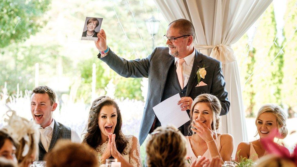 Orlagh's father holds up a photo of Angela Merkel