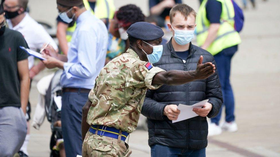 Soldiers guide members of the public to a vaccinate centre in Bolton