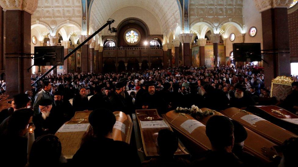 Coptic priests stand beside the coffins of victims a suicide bomb attack outside the Coptic cathedral in Alexandria (10 April 2017)