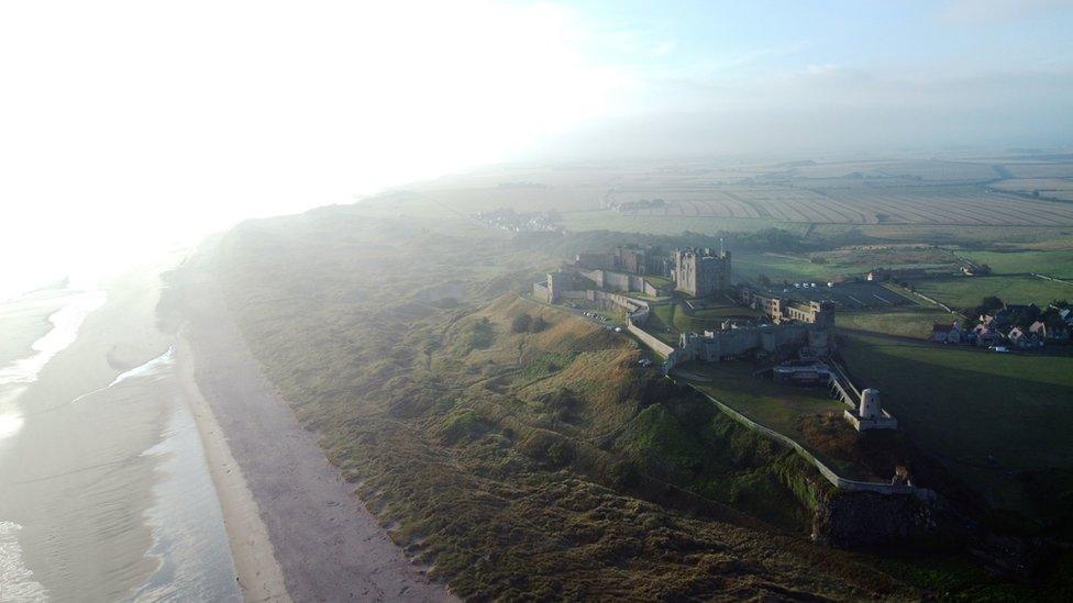 Aerial view of Bamburgh Castle in the mist