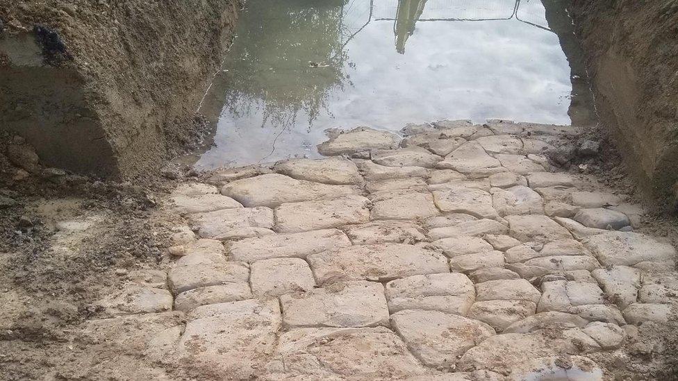 An old cobbled road next to a brook