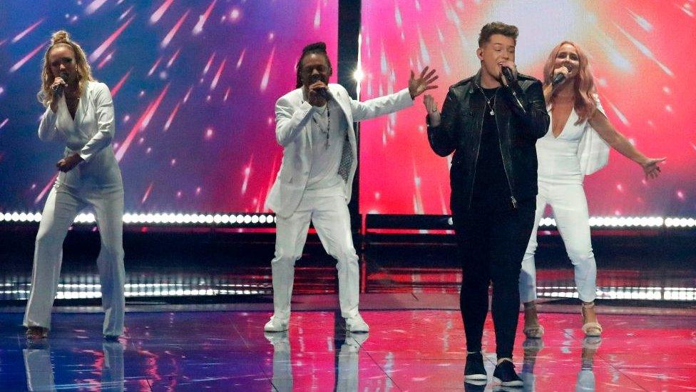 The UK entry to Eurovision 2019 Michael Rice sings on stage with back up dancers