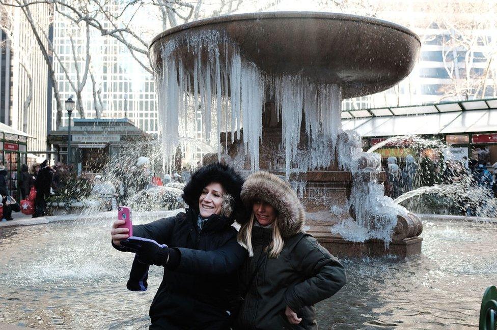 New York tourists take selfie in front of frozen fountain