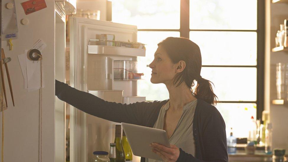 Woman opening fridge