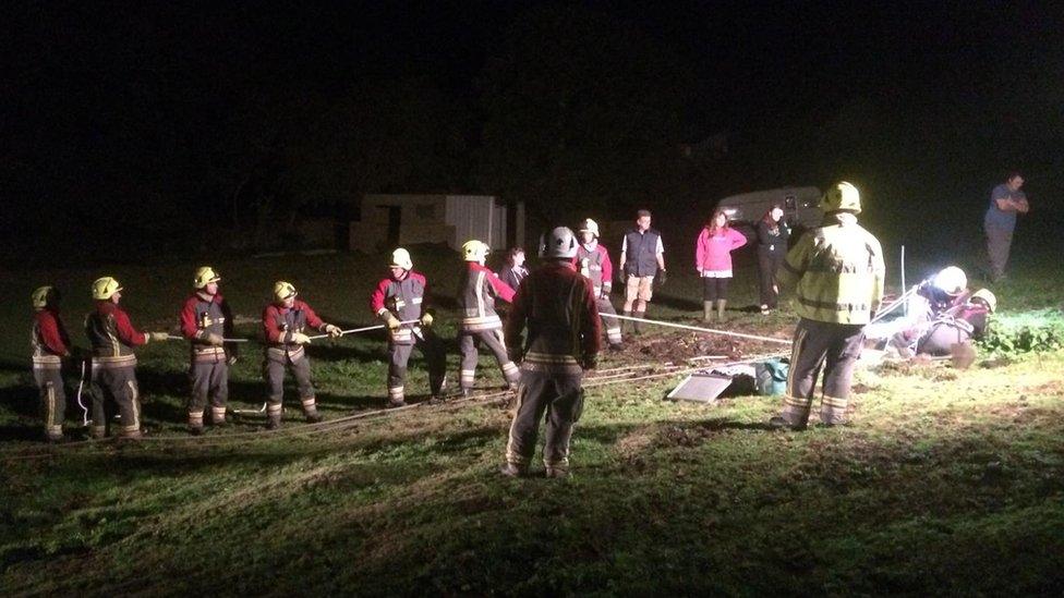 Firefighters holding line in dark field