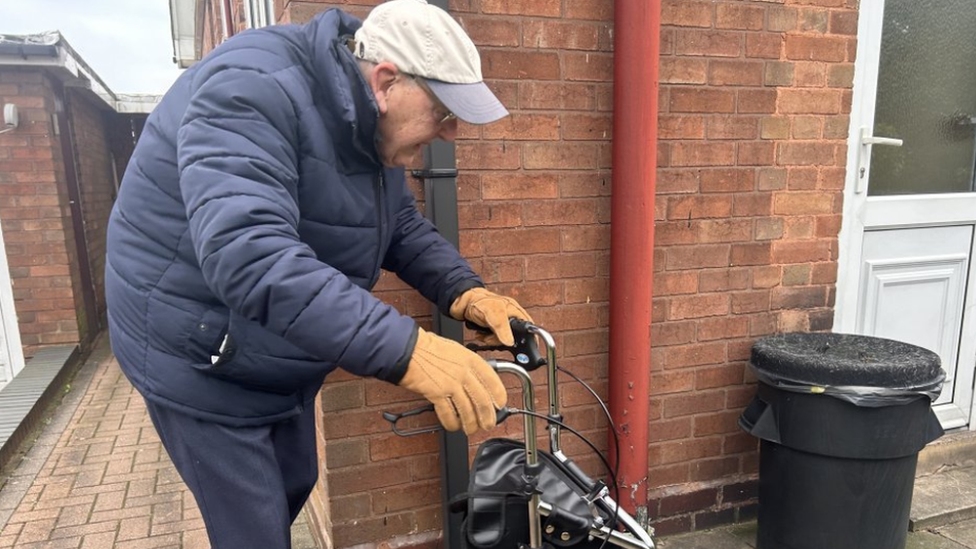 Mr Jones walking with mobility aid