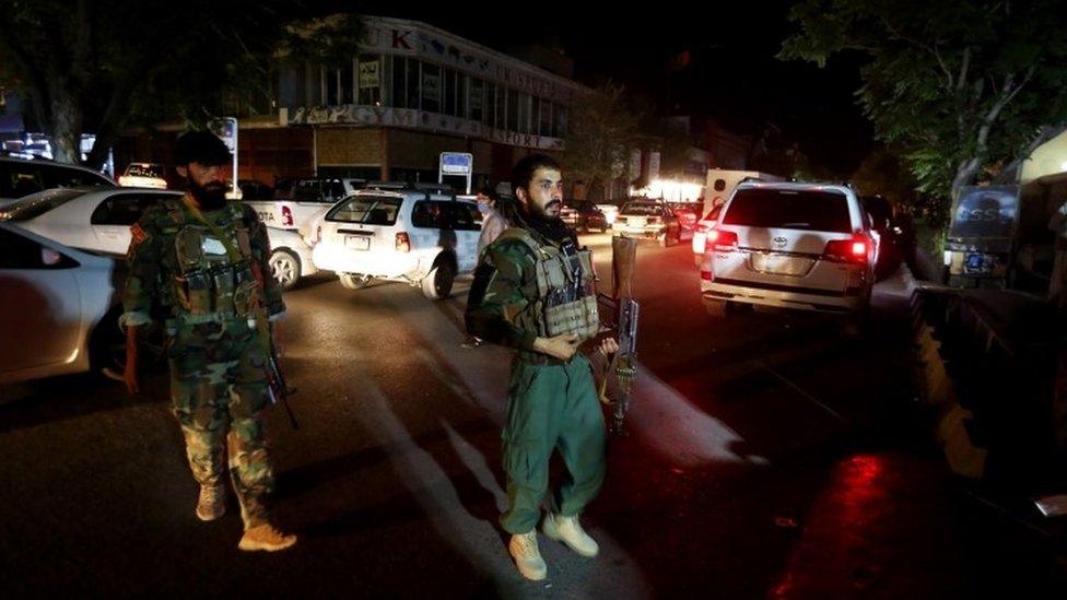 Afghan security officers stands guard outside the emergency hospital in Kabul after a car bomb blast