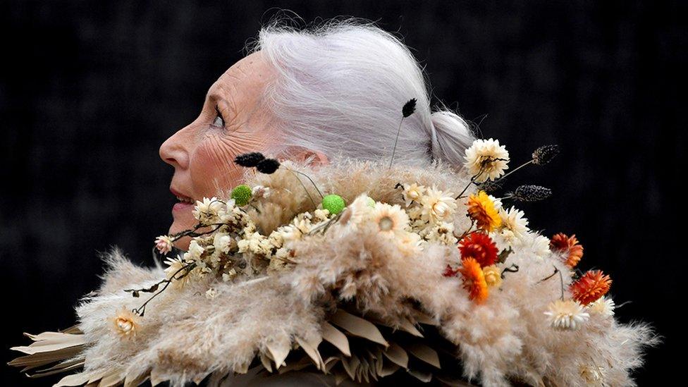 A woman wearing clothing made from dried flowers attends the RHS Chelsea Flower Show in London.