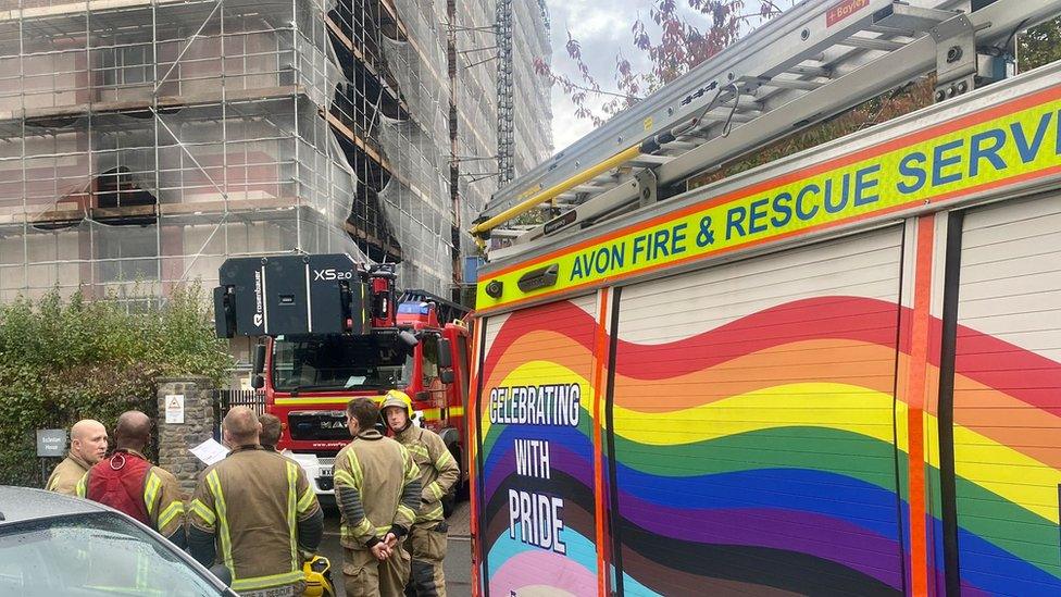 Firefighters outside burnt building