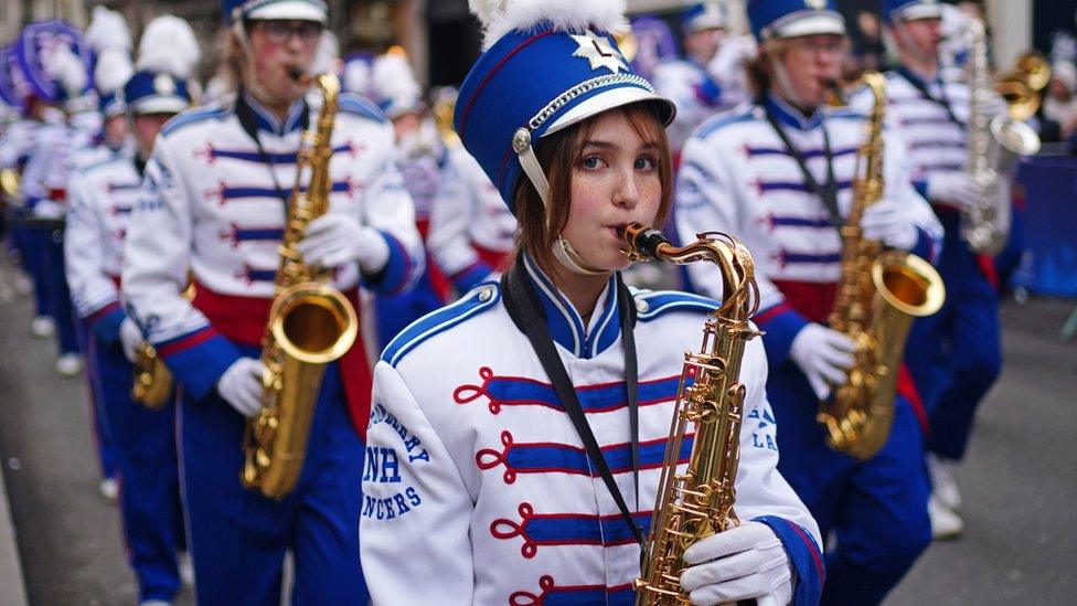 Performers in a band wear colourful outfits