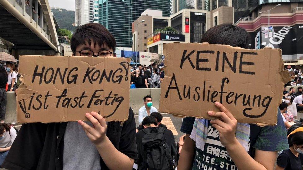 Two protesters holding up signs opposing the bill