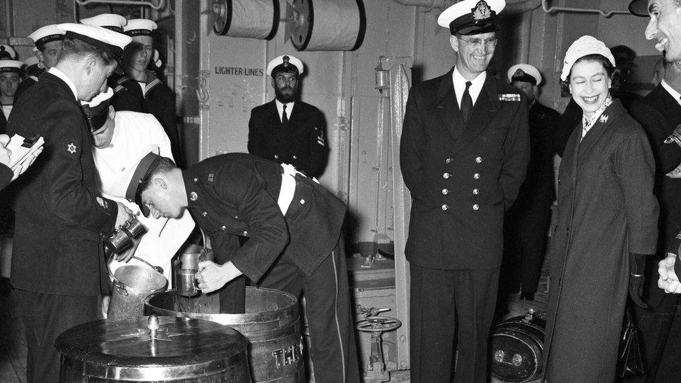 Queen Elizabeth II watches Victualling Officer B.R, Hailstone issuing the rum ration during her visit HMS Eagle at Weymouth, 29th April 1959