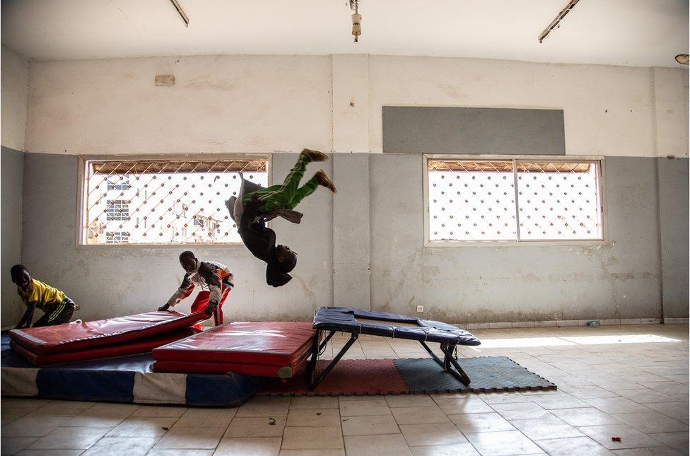 Young people train on a trampoline.