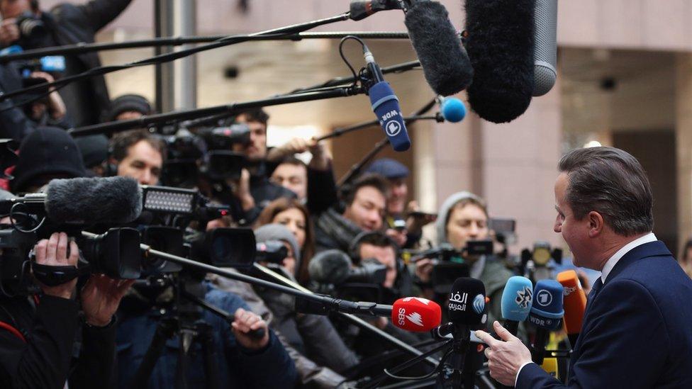 David Cameron surrounded by members of the press