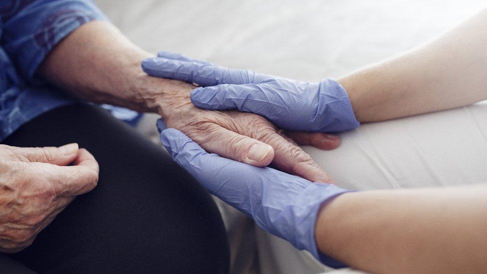 Carer holding hand of resident