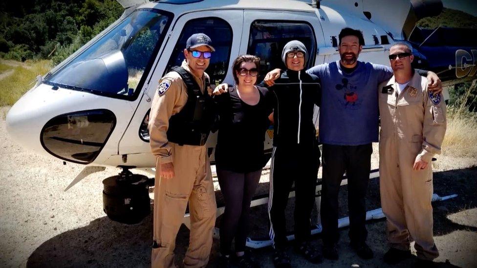 Krystal Ramirez (L), Hunter Whitson (C) and Curtis Whitson (R), pictured with rescue crew after their ordeal