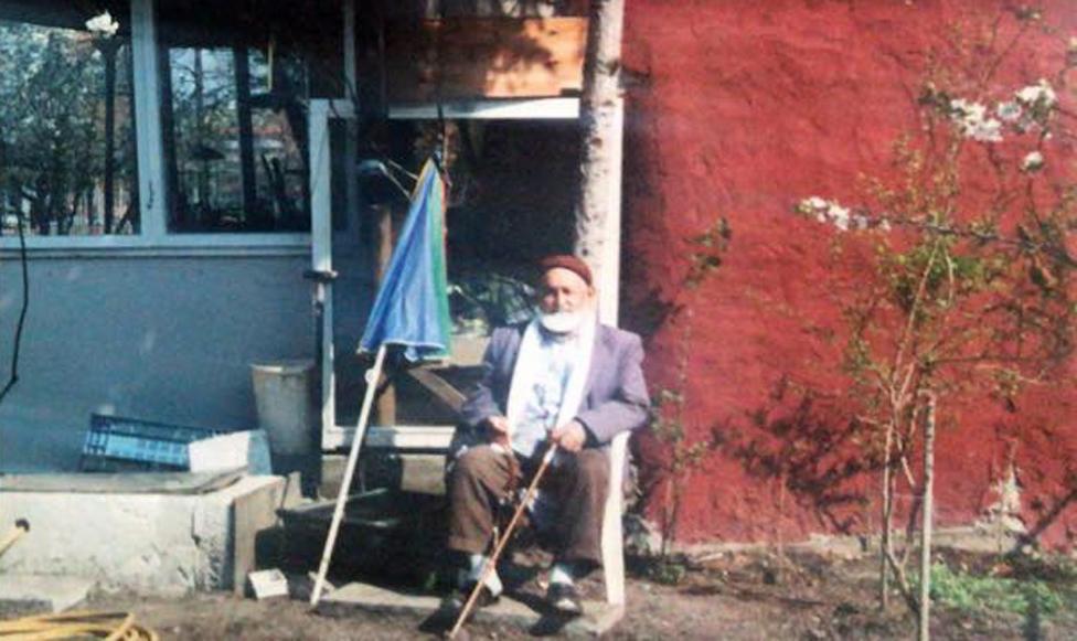 Osman in front of his house