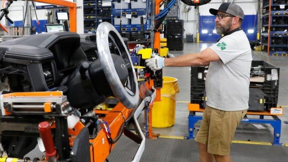 A man on a manufacturing line at Ford, which has announced thousands of job cuts