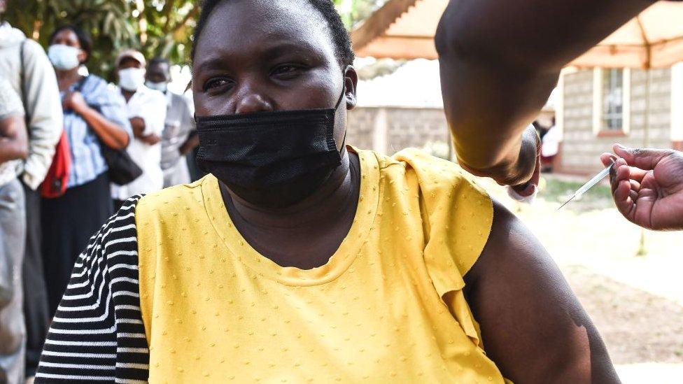 A Kenyan medic gives a dose of the AstraZeneca to a woman in Nairobi, Kneya - 10 August 2021