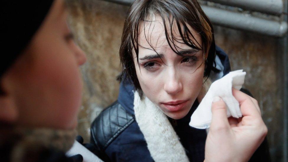 A paramedic rinses eyes of transgender activist at protest in Kiev