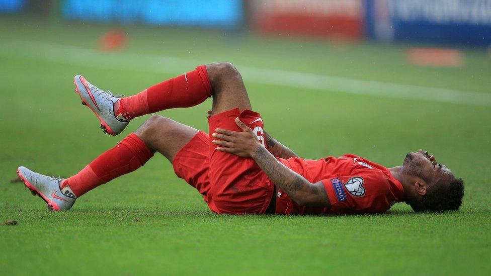 Raheem Sterling holds his leg during the UEFA European Championship Qualifying match in Slovenia.