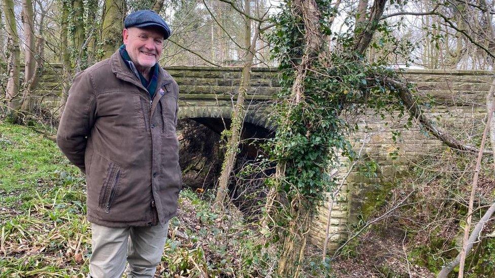 Colin Davidson standing above an overgrown railway track