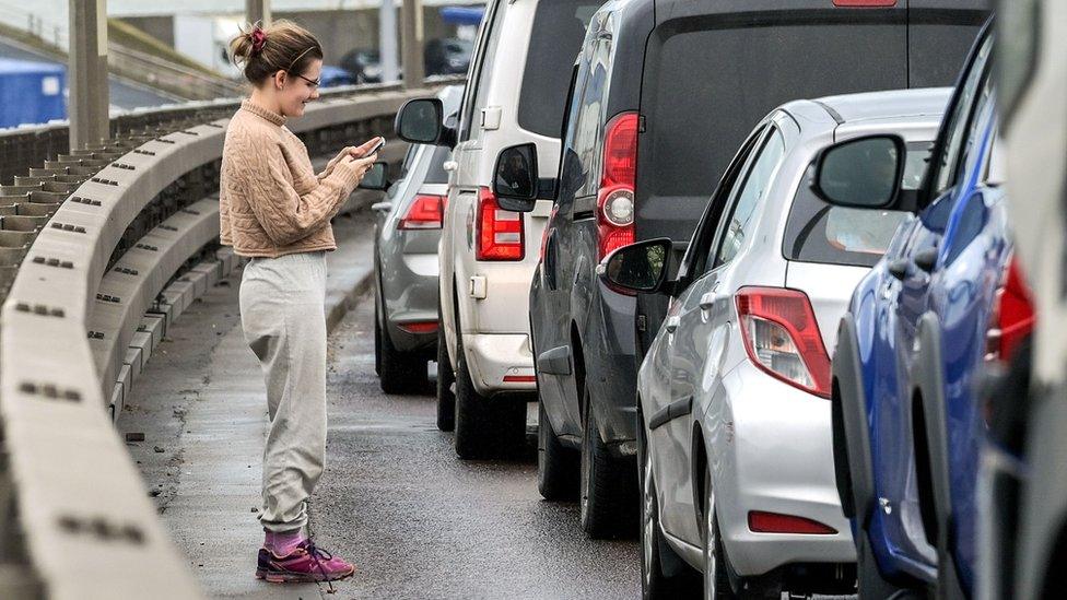 A person looks at her mobile phone while queueing at the Port of Dover, Britain, 01 April 2023.