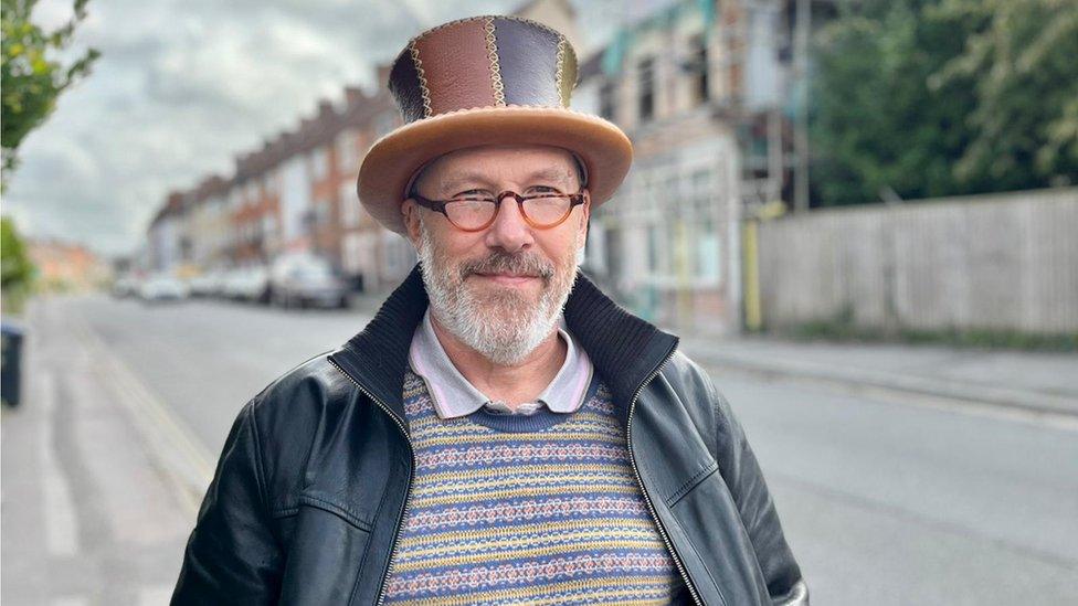 A man in a leather top hat