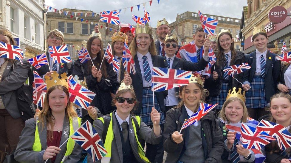 Children wearing crowns and waving flags at the parade