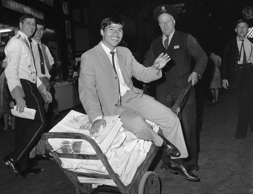 Humberto "Chita" Cruz of the Chilean World Cup squad gets a ride on a porter's cart at King's Cross railway station, 7 July 1966