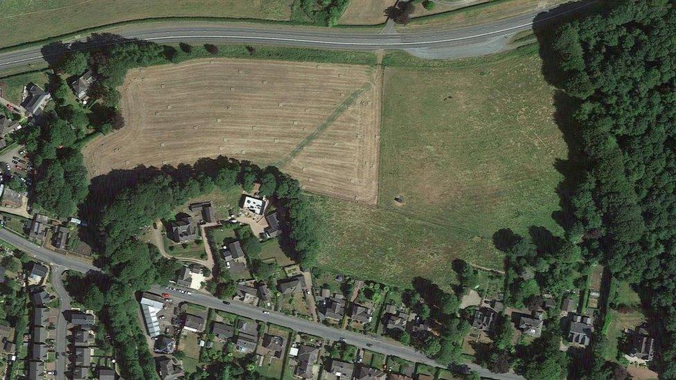 Aerial view of the proposed site, a field next to a road