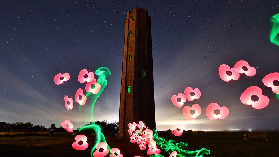 Naze tower photographed at night with lighting techniques to add poppies and light trails