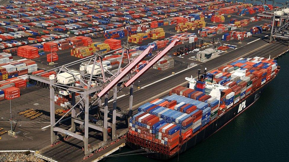 Shipping containers are left stacked in the Port of Los Angeles because of the West Coast lockout of dockworkers by shipping lines