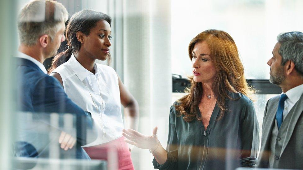 Female business executive leading team meeting